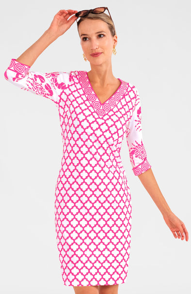 Blonde woman wearing pink and white geometric print 3/4 sleeve v-neck dress with contrast crab print on sleeves and brown sunglasses on her head