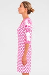 Blonde woman facing sideways wearing pink and white geometric print 3/4 sleeve v-neck dress with contrast crab print on sleeves 
