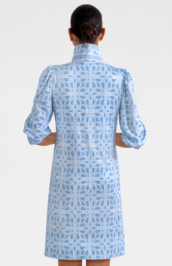Back view of the  Gretchen Scott Swagger Dress - Ring Toss - Periwinkle. A knee length dress with puff sleeves and a belt. A light blue geometric pattern on a white background