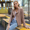 Model outside wearing Clara Sun Woo Liquid Leather Signature Jacket in Taupe with White Tee and Jeans