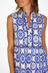 Model in a sleeveless blue tile patterned mini length dress