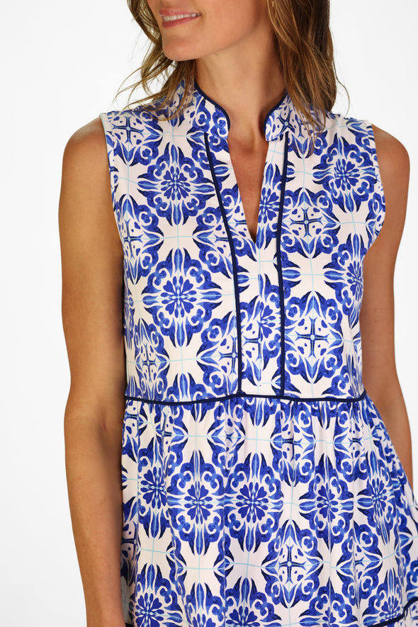 Model in a sleeveless blue tile patterned mini length dress