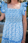 Blue and white patterned dress with ruffled sleeves worn by a person.
