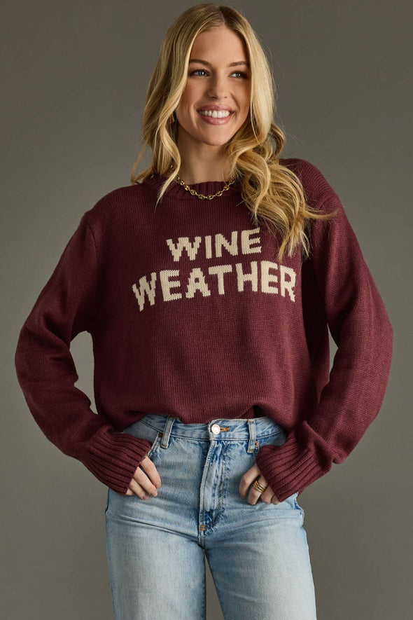 Woman wearing a maroon sweater with 'WINE WEATHER' text on a gray background
