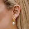 The Susan Shaw Mini X Pearl Drop Stud Earrings on model's ear