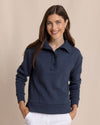 Woman wearing a navy blue pullover with a collar on a beige background