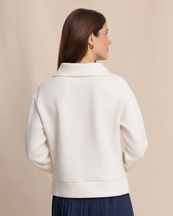 Woman wearing a white jacket against a beige background