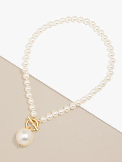 Zenzii Pearl Pendant Necklace layed flat on two-tone display