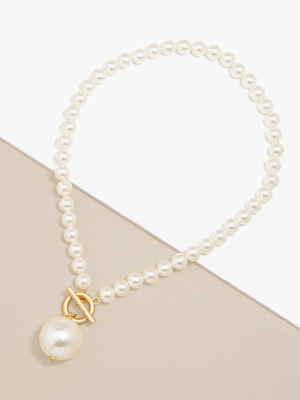 Zenzii Pearl Pendant Necklace layed flat on two-tone display