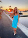Model by the water wearing Jude Connally Bailey Dress in Santorini Blue