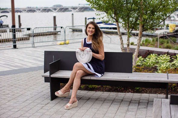 Outdoor model sitting in Duffield Lane Carroll Dress - Navy/White