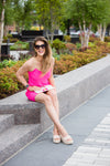 Model sitting wearing Jude Connally Bailey Dress in Spring Pink