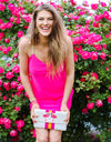 Model in front of hot pink roses wearing Jude Connally Bailey Dress in Spring Pink