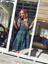 Model in a doorway in Gretchen Scott Teardrop Dress Plaidly Cooper Green Plaid