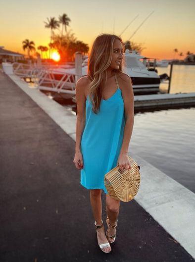 Model outside at sunset wearing Jude Connally Bailey Dress in Santorini Blue