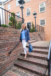 Model walking down steps in Renuar Ankle Pants White