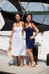 Two models on a dock, right model wearing Jude Connally Bailey Dress in Navy