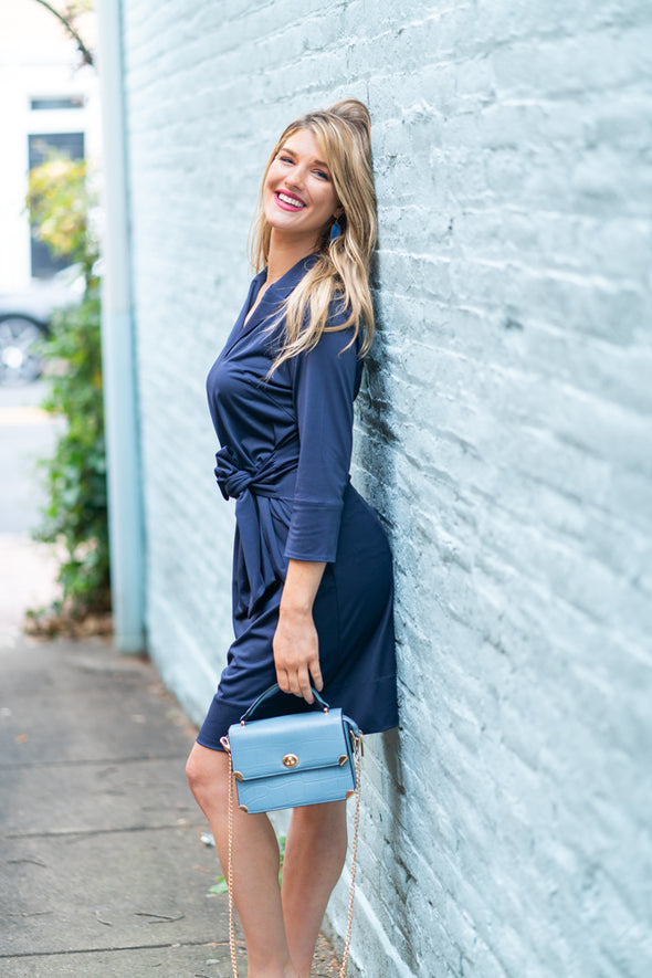 Model against wall wearing Gretchen Scott Dapper Dress in Solid Navy