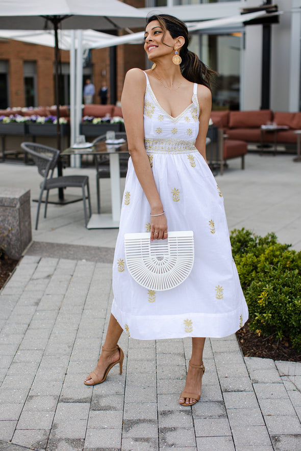 Model with white bamboo purse wearing Gretchen Scott Fiesta Time Dress in White/Gold