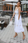 Side view of model wearing Gretchen Scott Fiesta Time Dress in White/Gold outside, hands in pocket