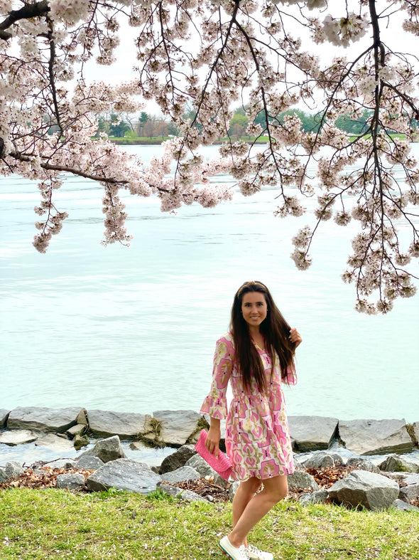 Model under cherry blossoms wearing Jude Connally Faith Dress in Butterfly Tile White/Gold
